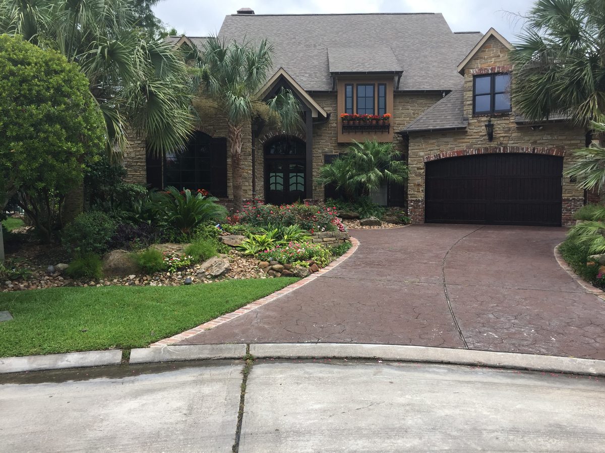 Luxury stone estate home with manicured front yard landscaping by TruLeaf